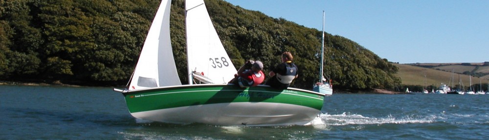 Two adults leaning out on Comet Trio in Salcombe Harbour