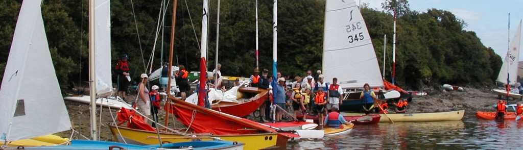 Many dinghies, adults and children on the beach in the Helford River