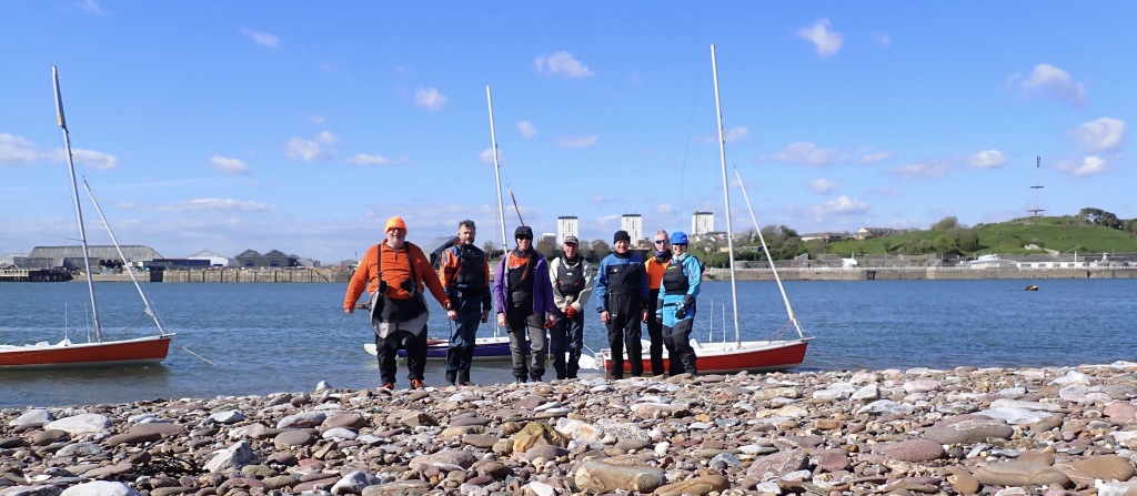 People standing in front of sailing dinghies