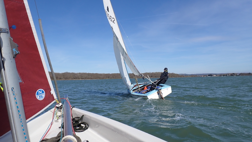 Two sailing dinghies beating into the wind.