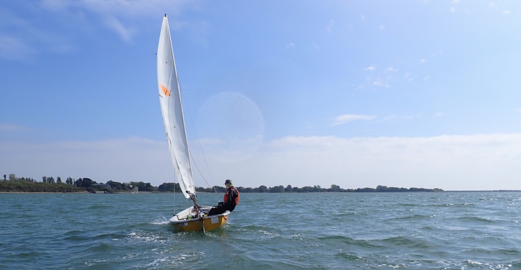 Sailing dinghy in bright sunlight and a clear blue sky